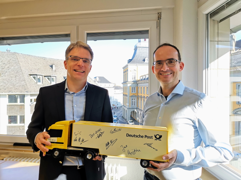 CEO Martin Schulze und Managing Partner Martin Bernemann mit einem „Deutsche Post DHL“-Truck zum BusinessCode Jubiläum